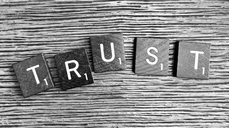 trust spelled with wooden letter blocks on a table